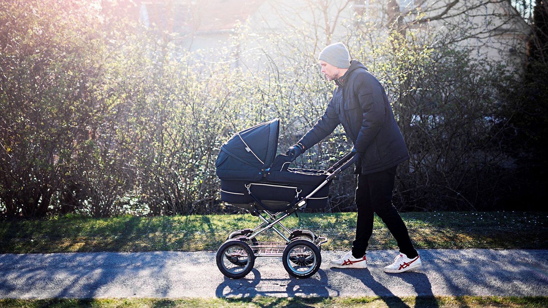 Billede af en mand, der går tur med barnevogn
