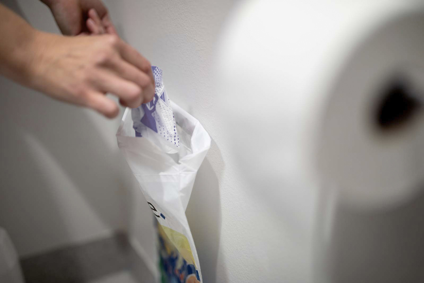 Billede af en hånd, der håndterer menstruationsbind.