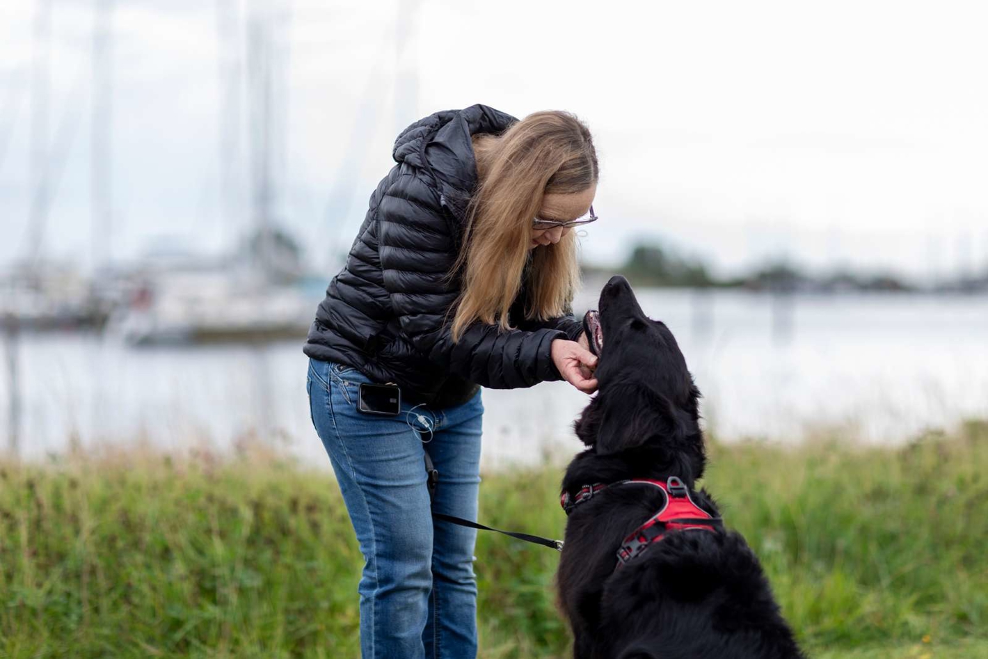 Billede af kvinde, som har insulinpumpe på og lufter sin hund.